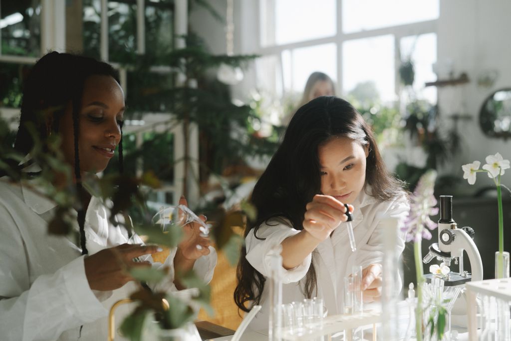 Two women in a laboratory surrounded by plants.